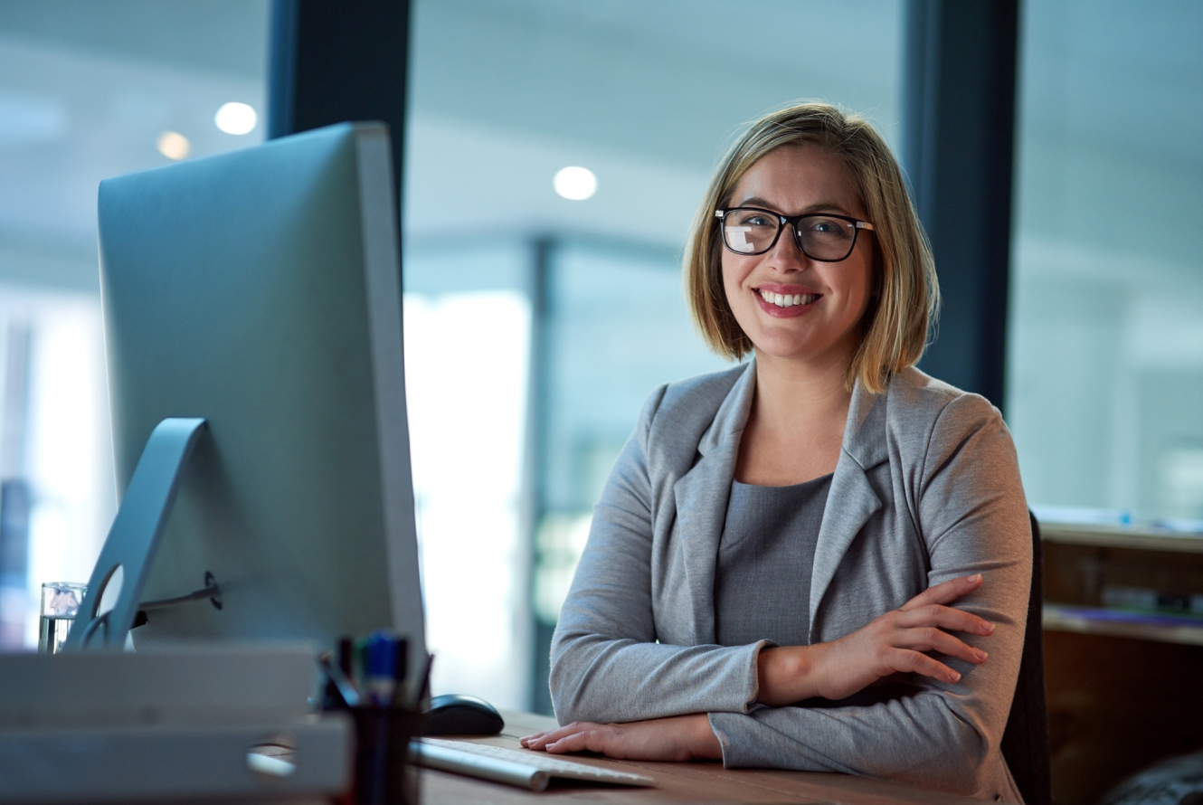 Mujer profesional sonriendo durante videollamada desde oficina.