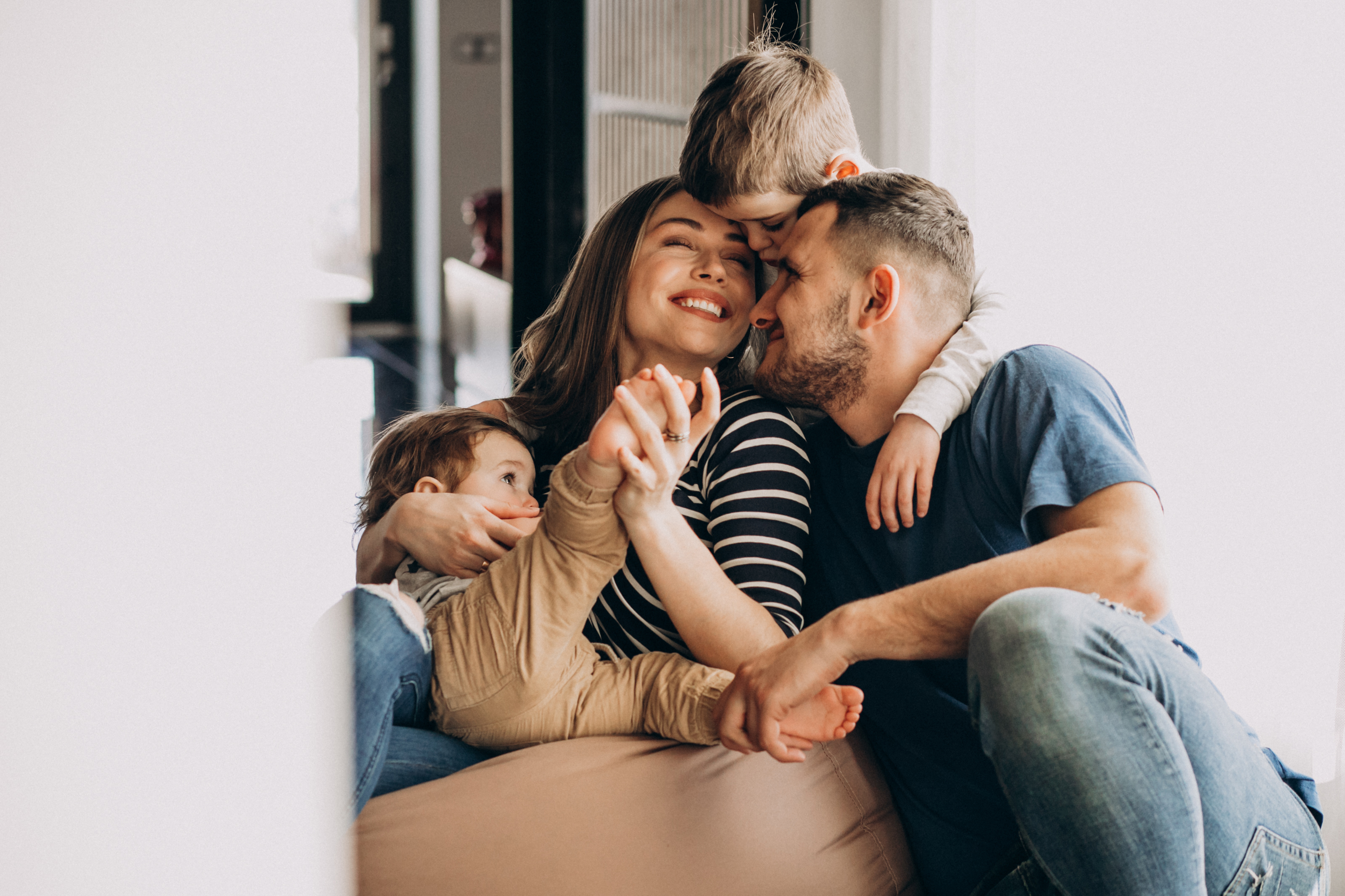 Familia joven con sus hijos divirtiéndose en casa