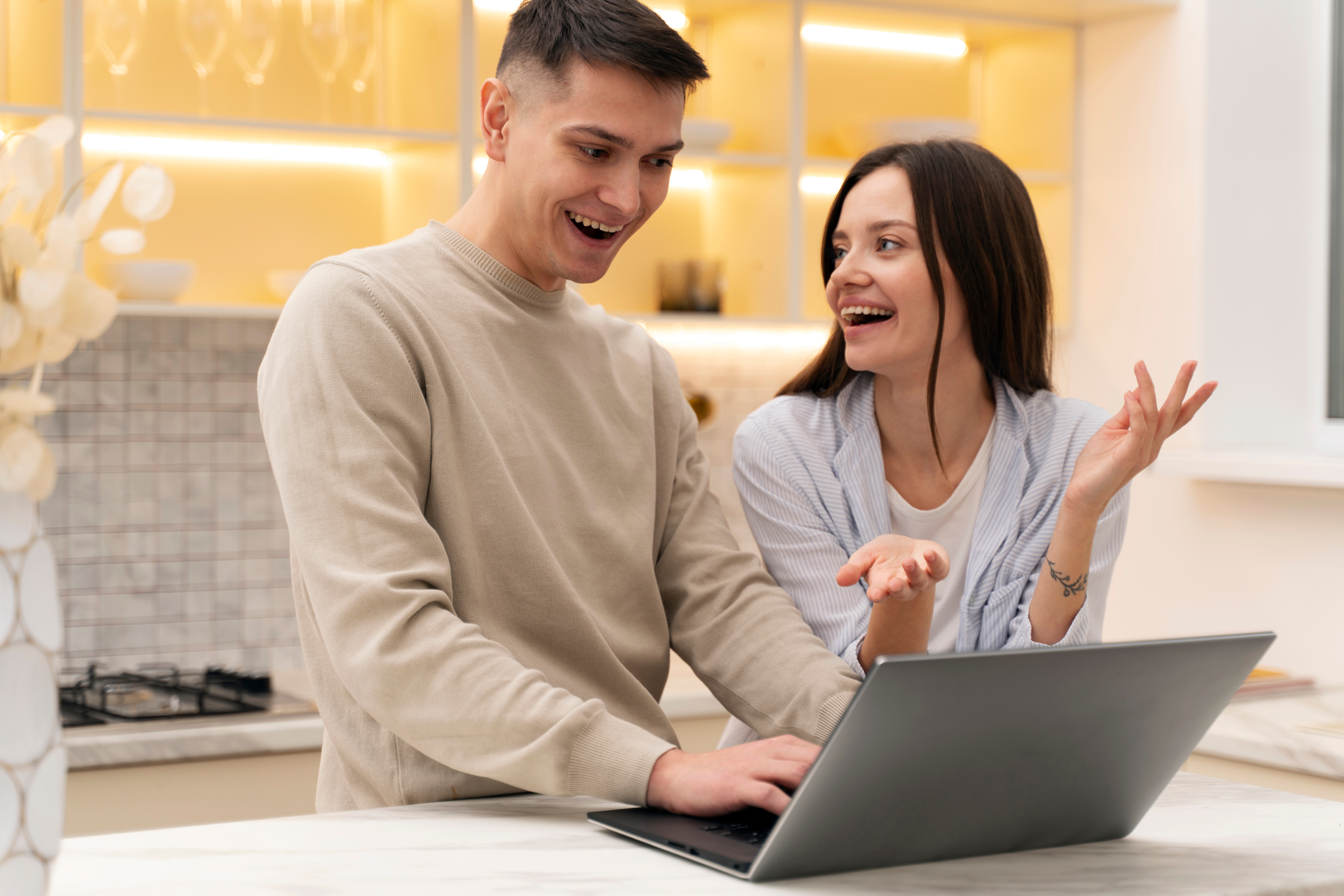 Pareja revisando información en un portátil.