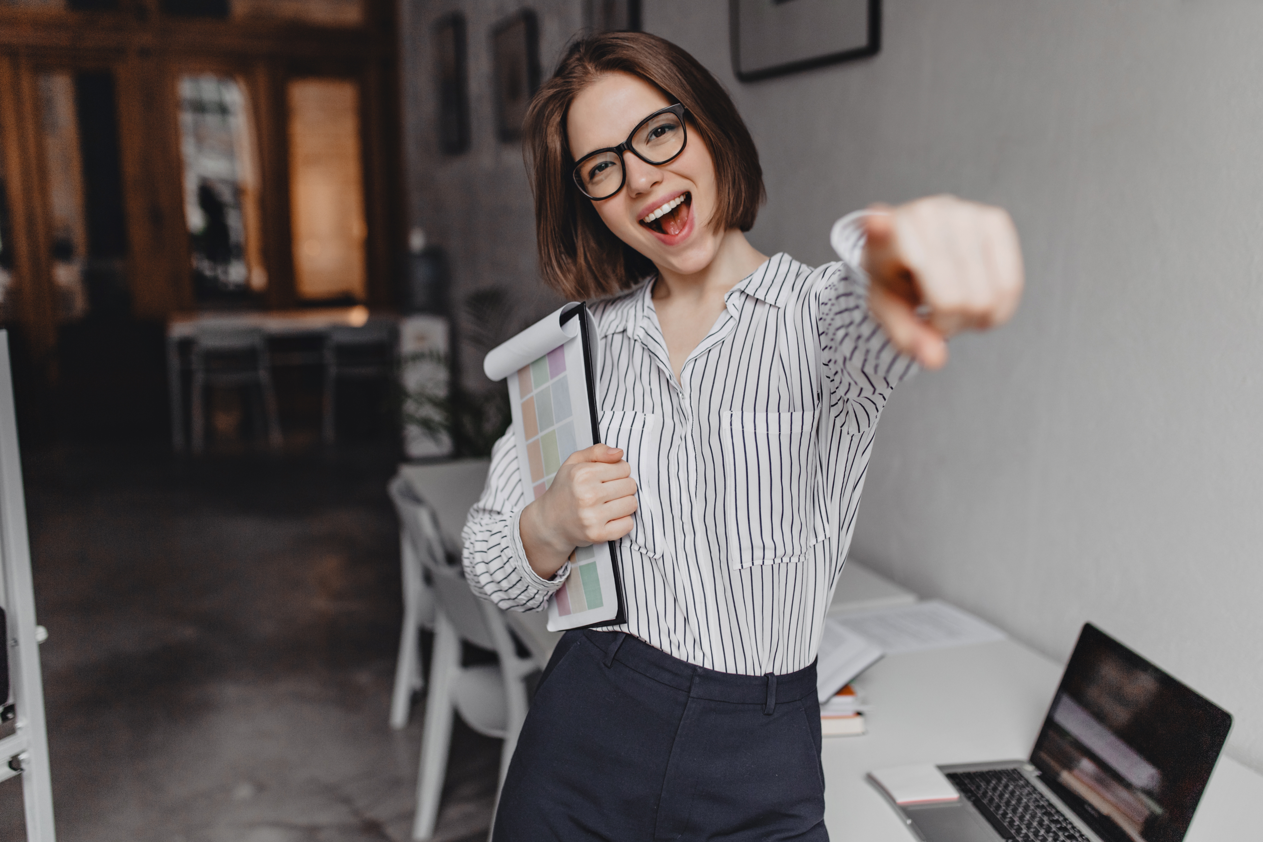 Mujer sonriente usando portátil en espacio de trabajo.